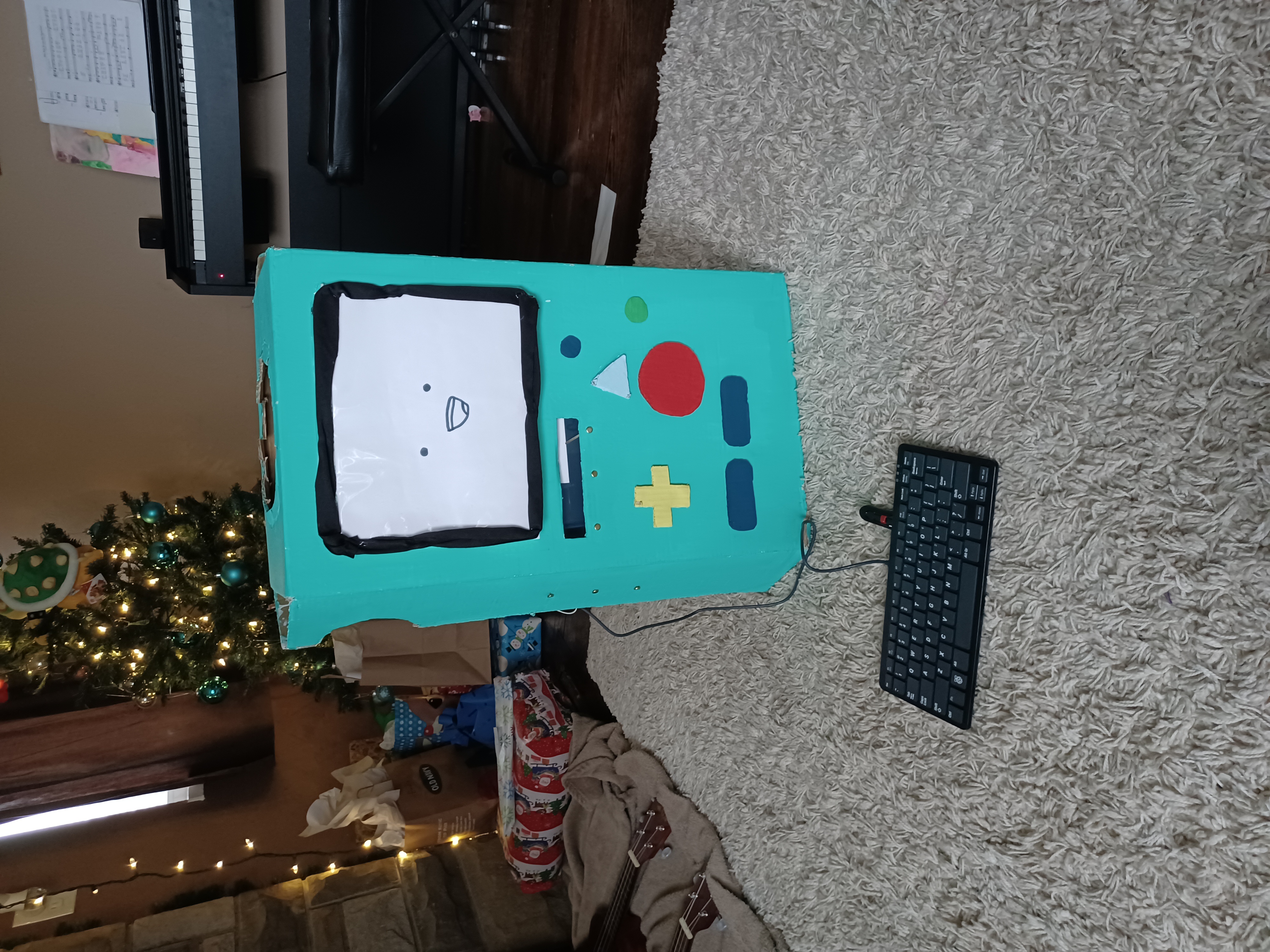 A cardboard box painted and cut to look like the Adventure Time charachter BMO. Now it has a keyboard trailing out with a cord.