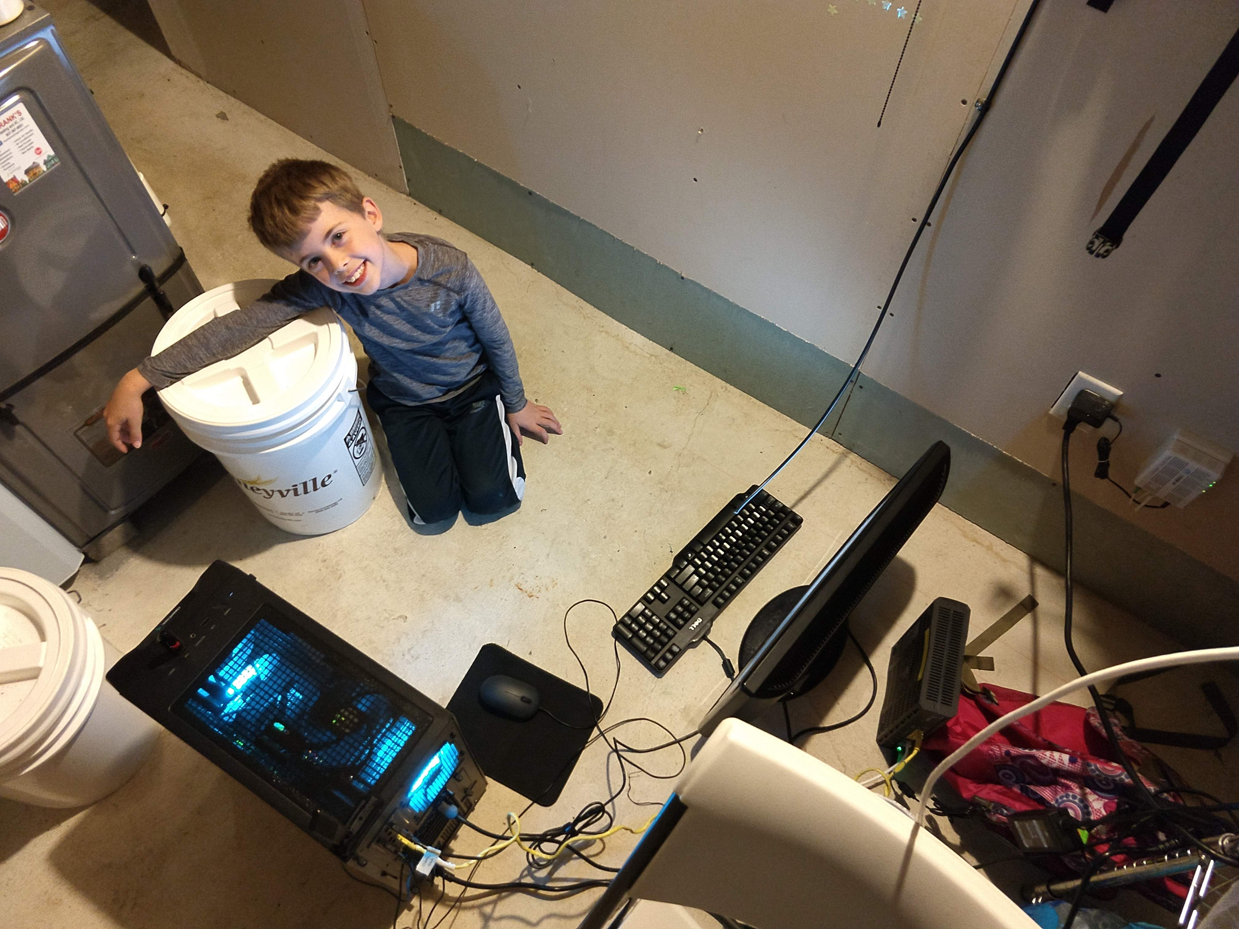 happy austin in the basement next to a computer on the floor