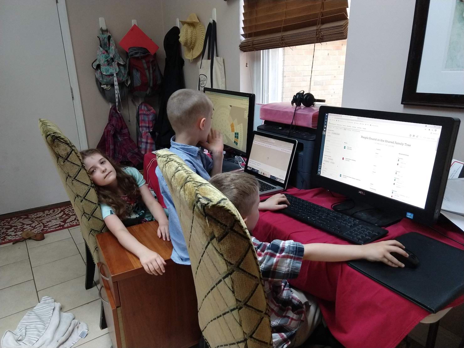 children working at computers, one of them is flopped over, frustrated