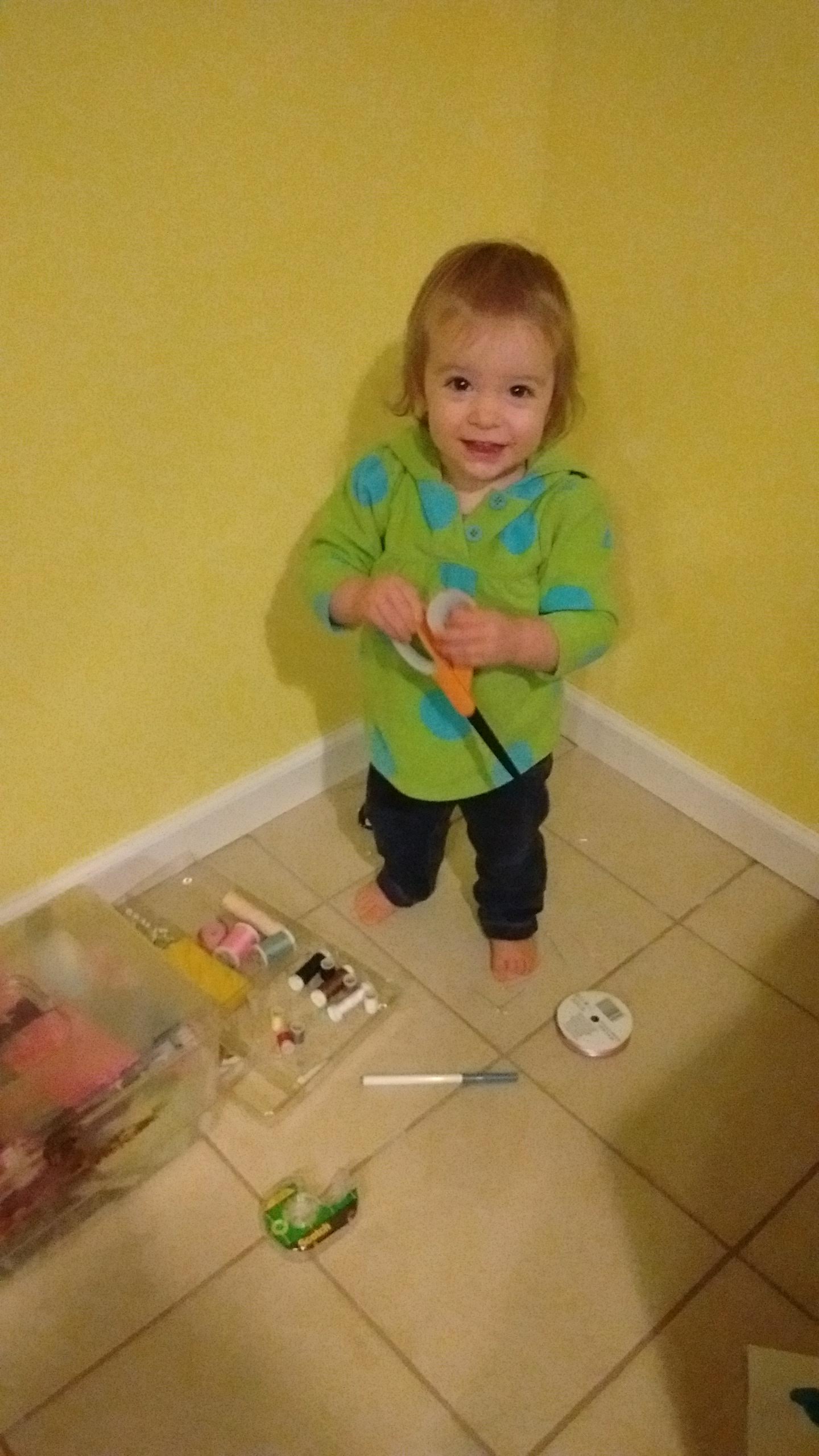 a toddler holding scissors