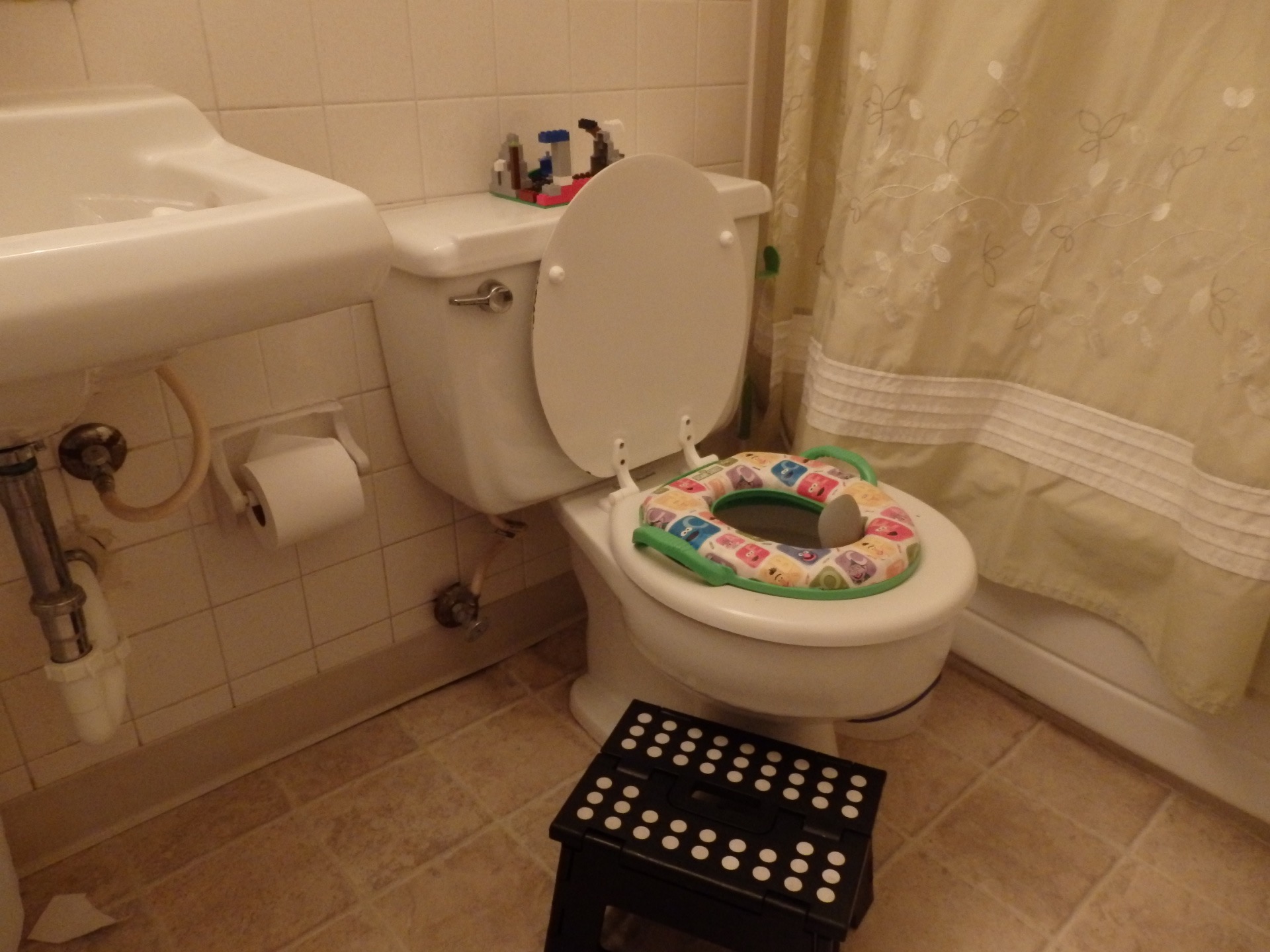 a child's lego building sitting on the toilet tank