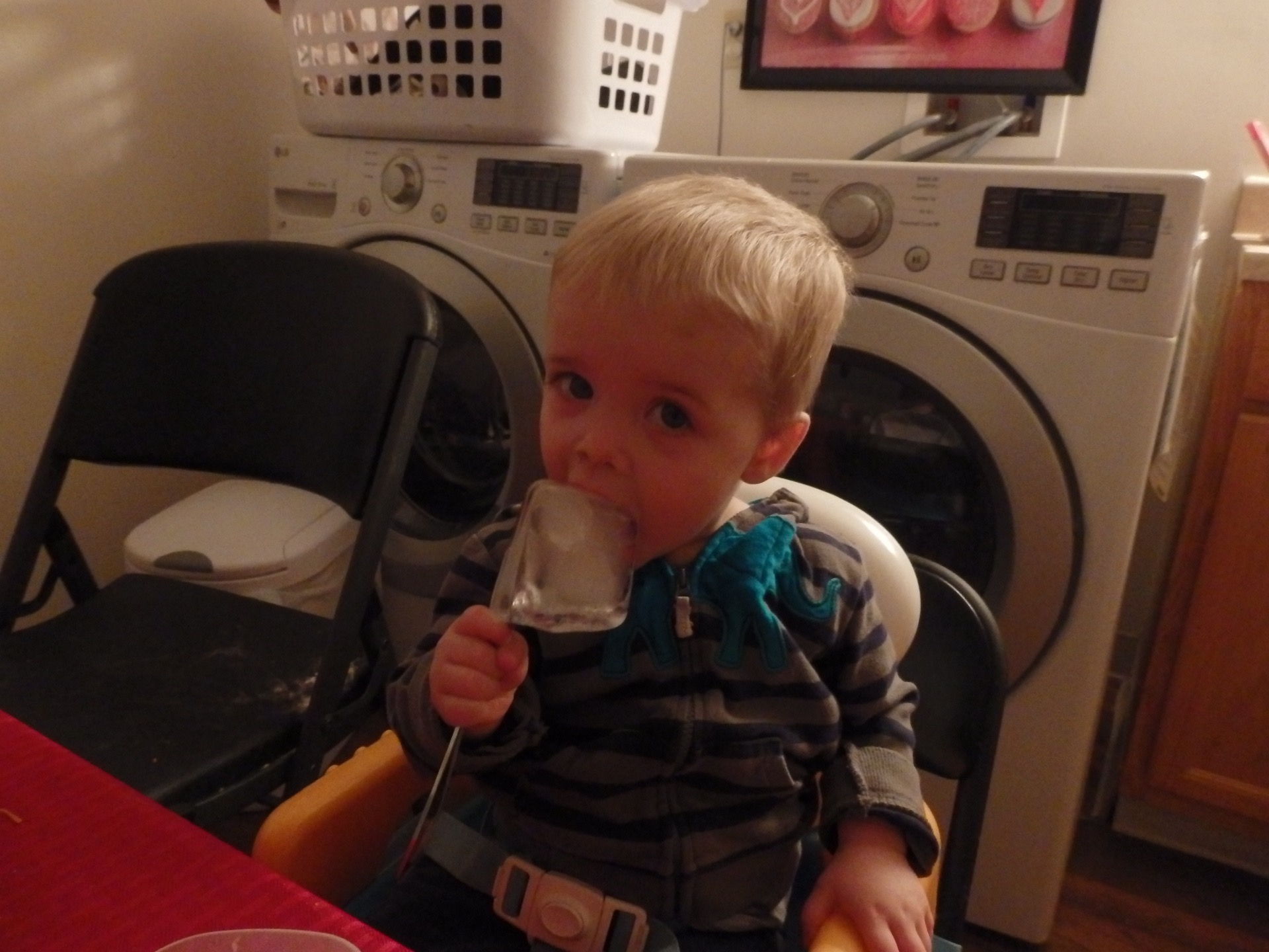 Austin eating a popsicle made from a spoon in a glass of water in the freezer