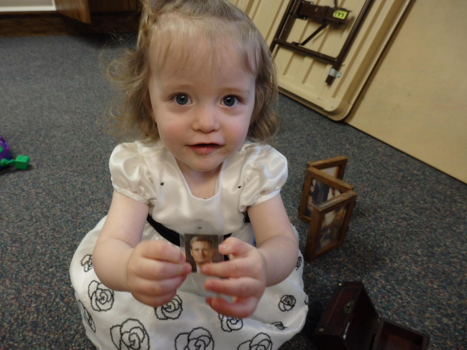 toddler holding a picture of Elder Bednar