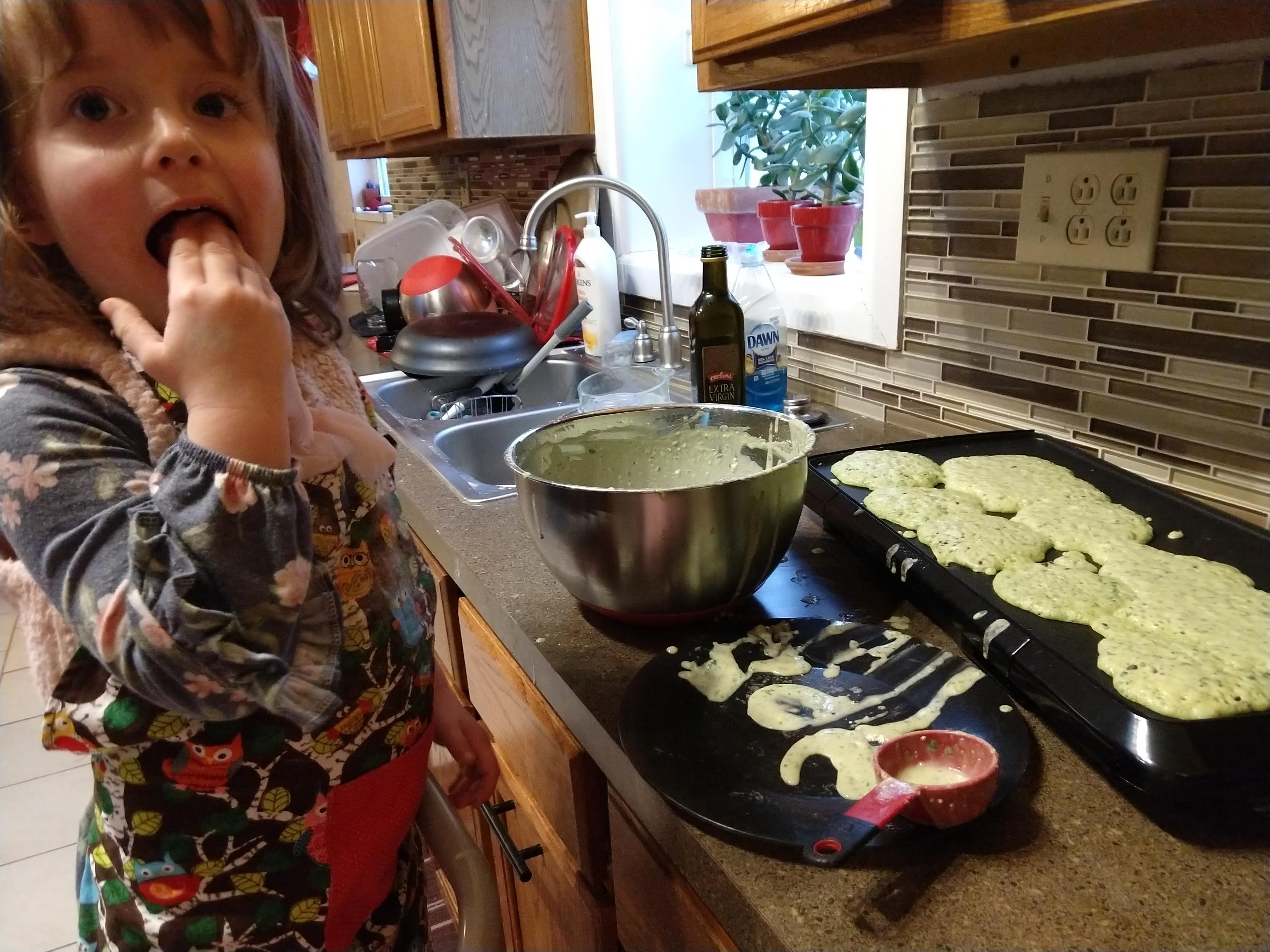 a toddler licking the batter