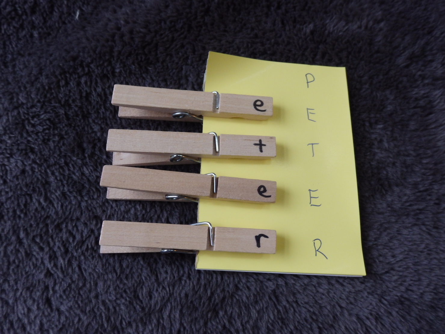 clothespins with letters on them that match letters on a paper it's clipped to
