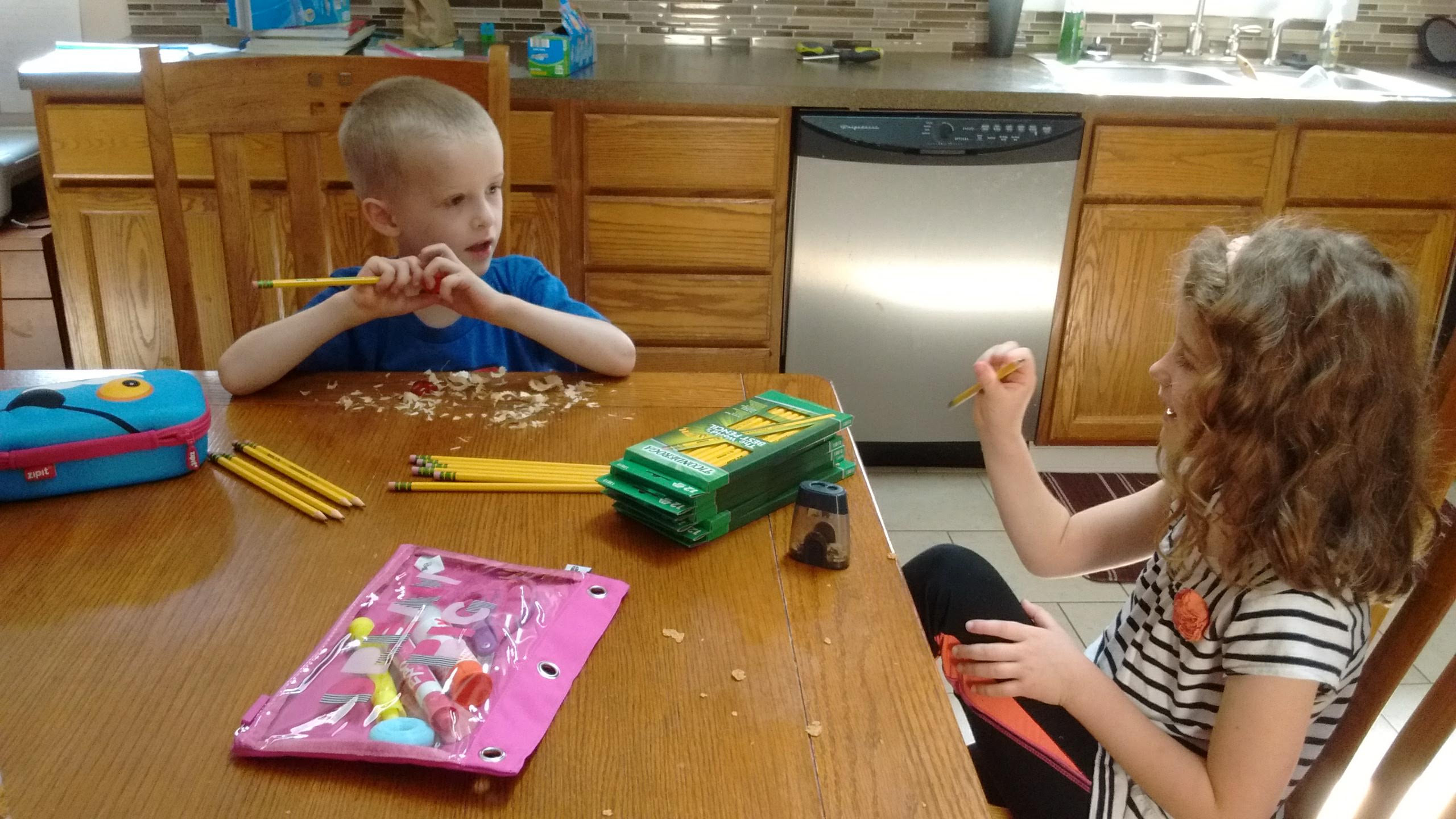 kids sharpening pencils with a manual sharpener