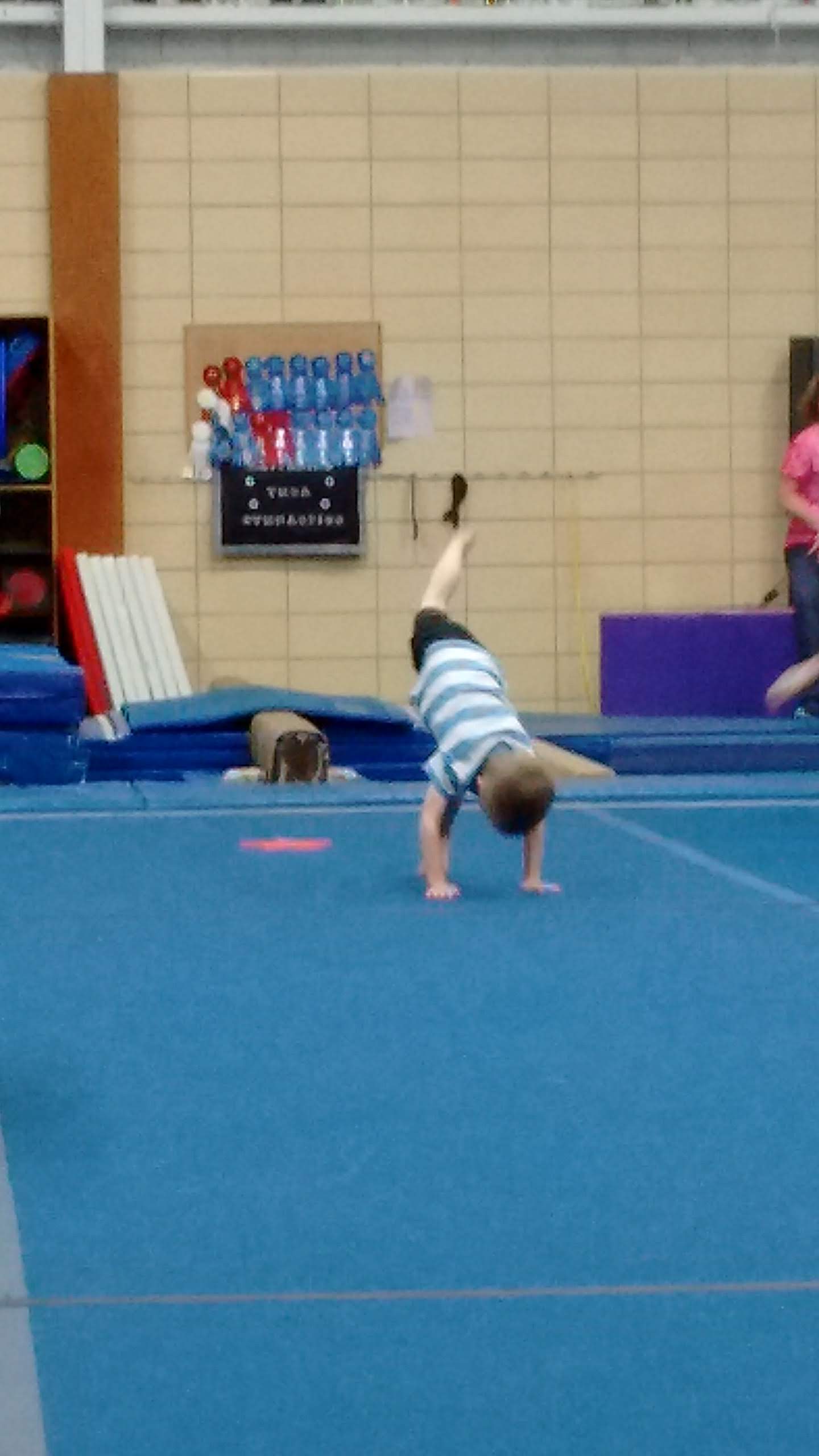 boy in a gymnastics class practicing a handstand