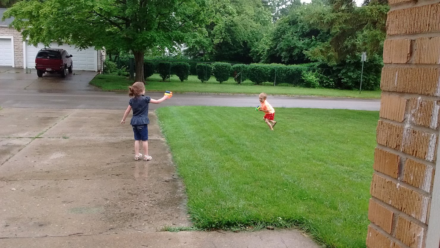 children playing with squirt guns outside