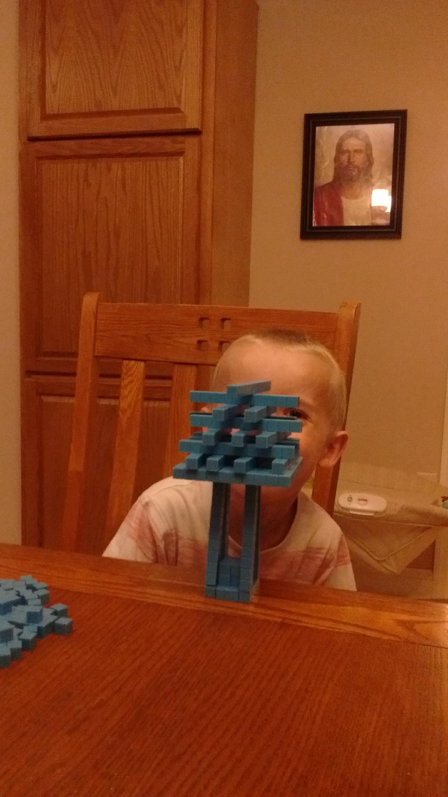 a child balancing tiny base ten blocks on each other