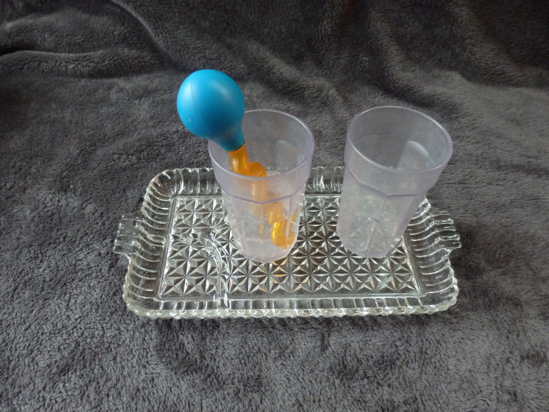 a glass tray with two cups and a pipette to transfer water