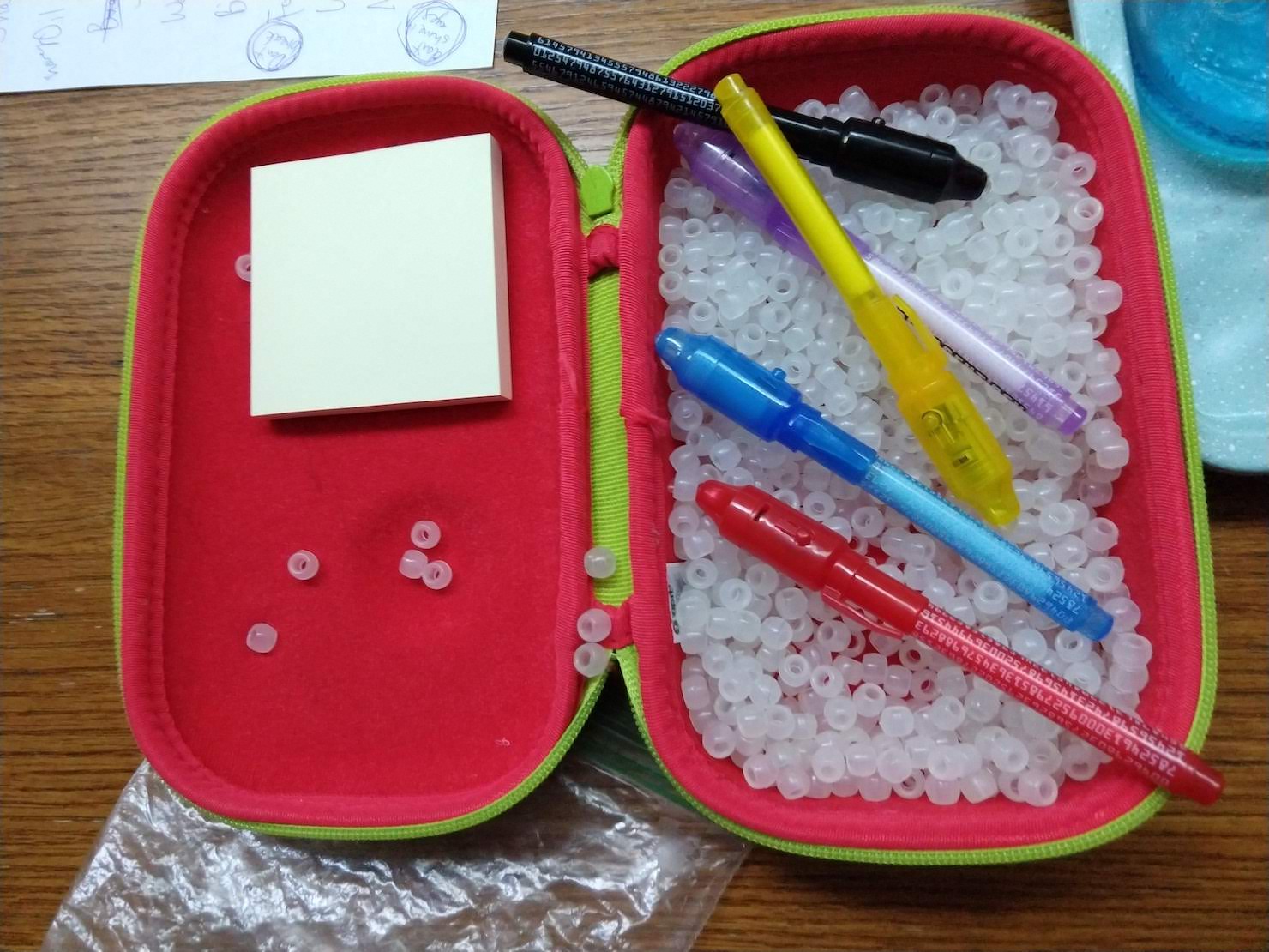 a box of white beads with UV pens and lights. 