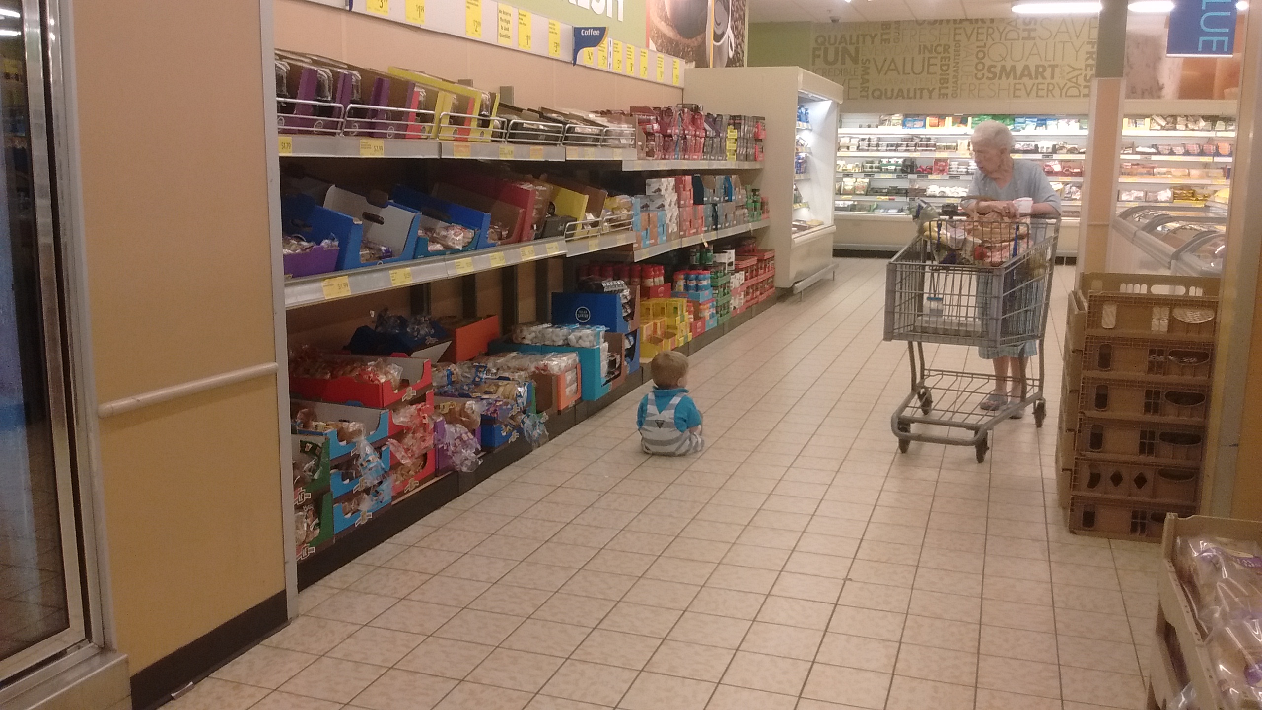 austin sitting on the grocery store floor