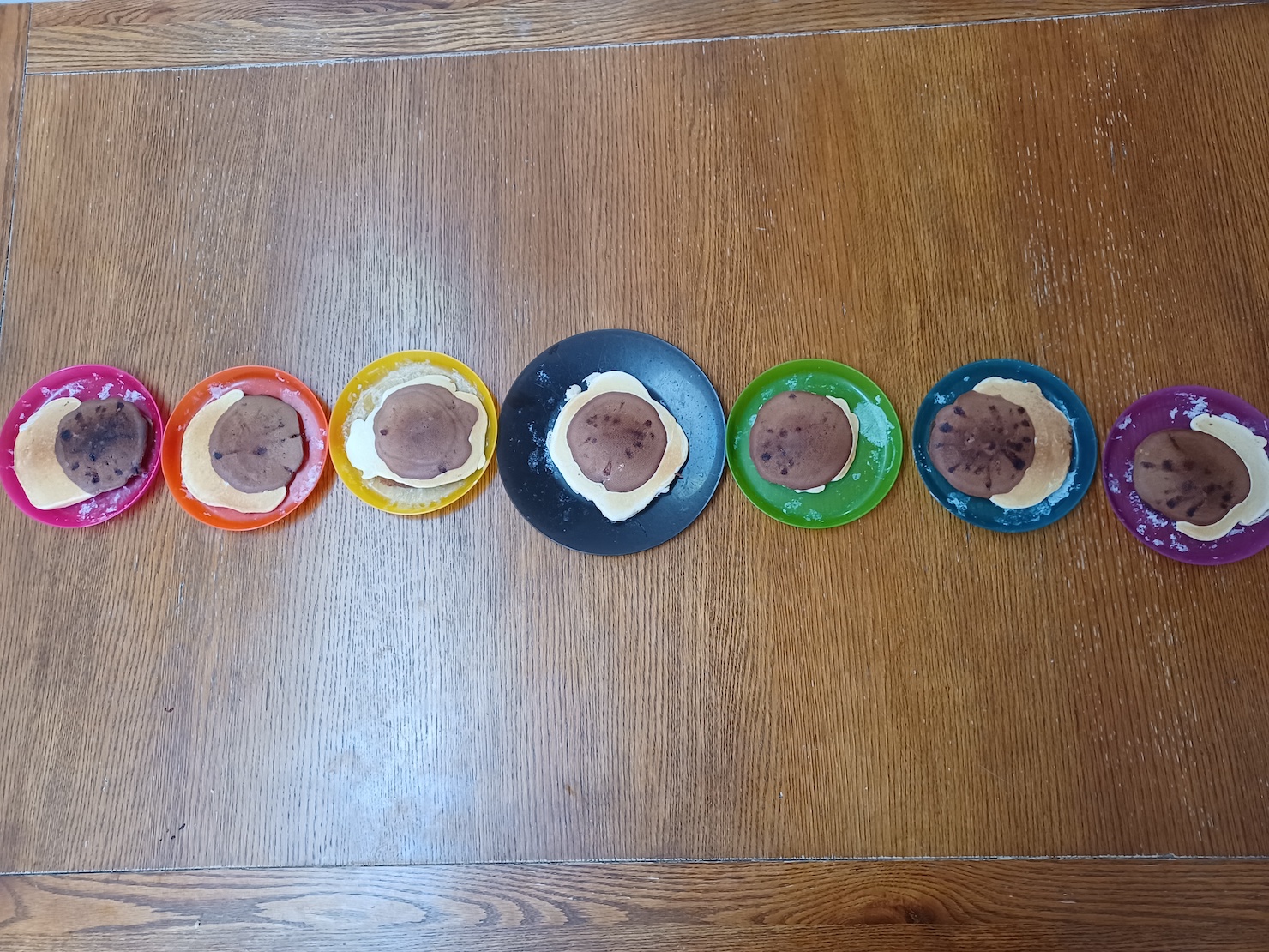 Chocolate and Regular pancake batter dribbled in eclipse shapes: 7 plates ranging from sun half covered to bailey's beads, to diamond ring, to totalality